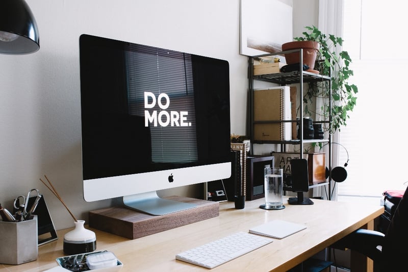 Computer on desk, with "Do More" written on screen