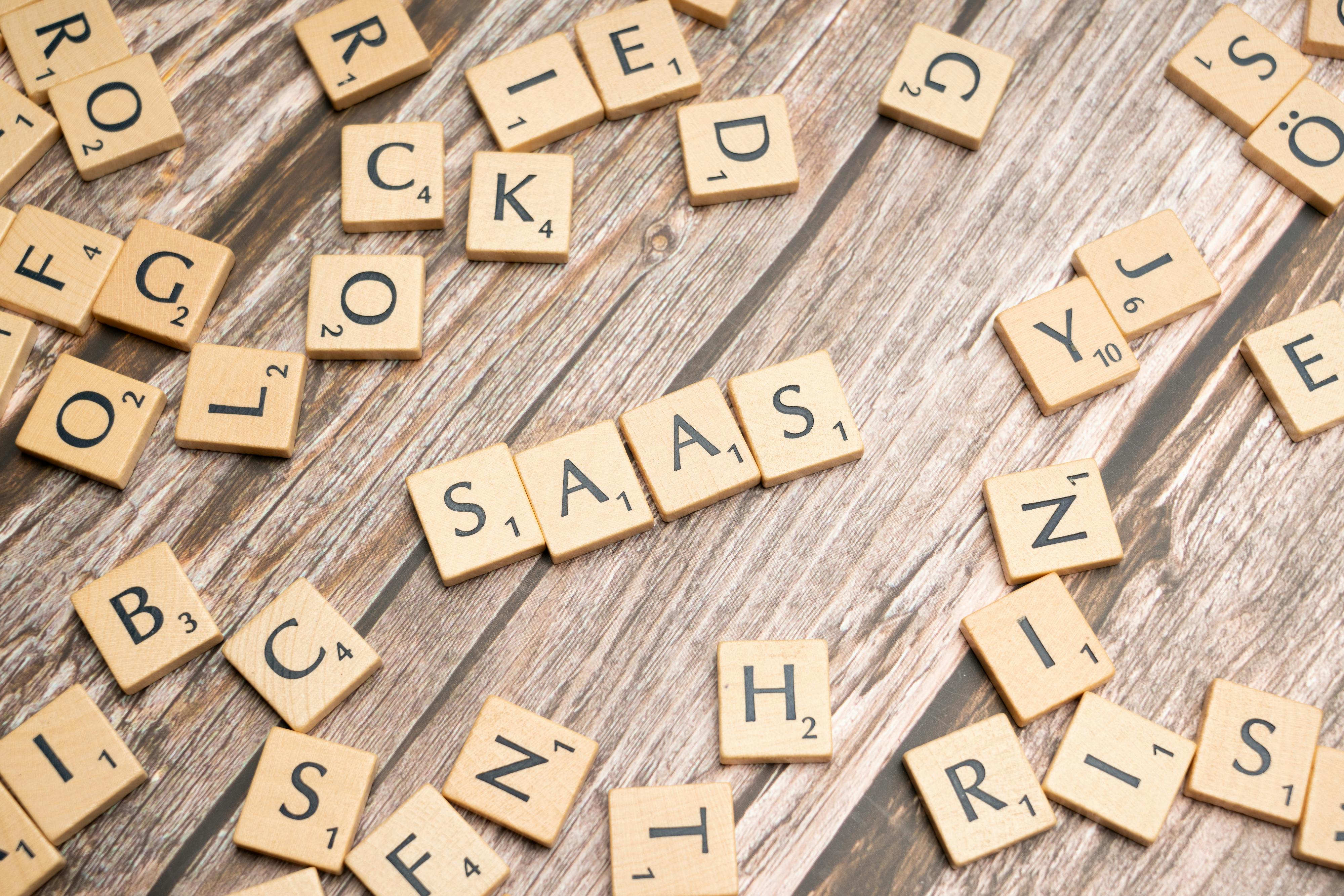 Scrabble letters spelling SaaS on a wooden table